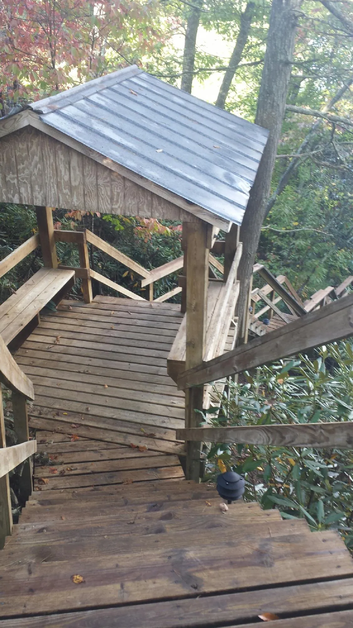 Metal roofed shelter over wooden steps on a wooded walkway — Skylight Repair & Installation work by our crew in Dorr